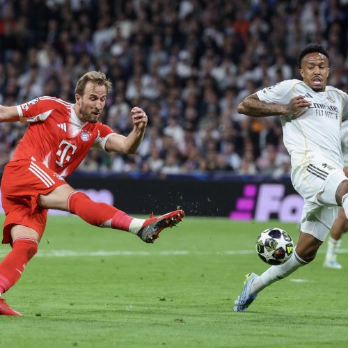 Bayern Munich's English forward #09 Harry Kane (L) shoots challenged by Real Madrid's Brazilian defender #03 Eder Militao during the UEFA Champions League quarter final first leg football match between Real Madrid CF and FC Bayern Munich at Santiago Bernabeu Stadium in Madrid on April 7, 2026. (Photo by Pierre-Philippe MARCOU / AFP)